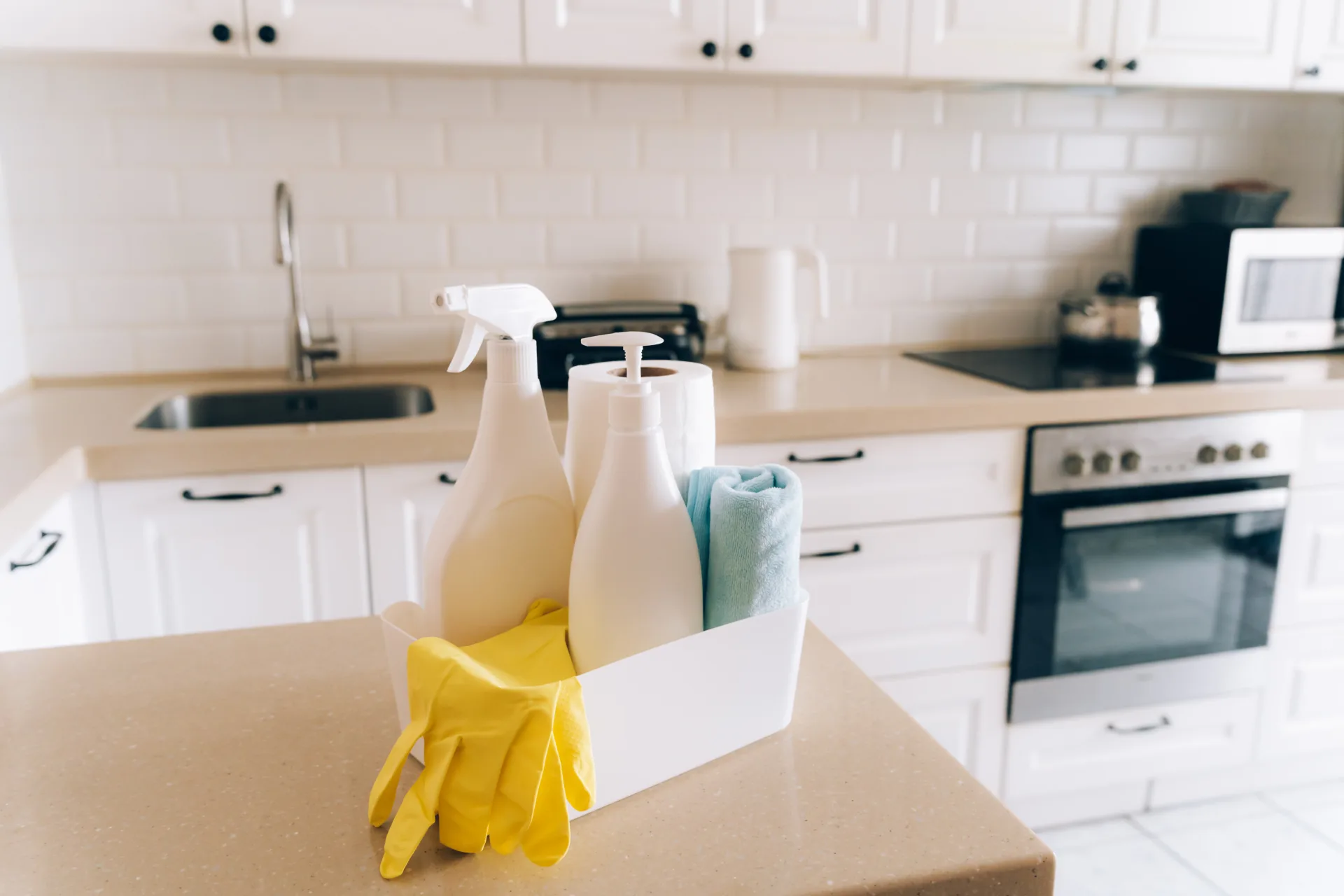 Cleaning supplies and gloves set out on a kitchen counter